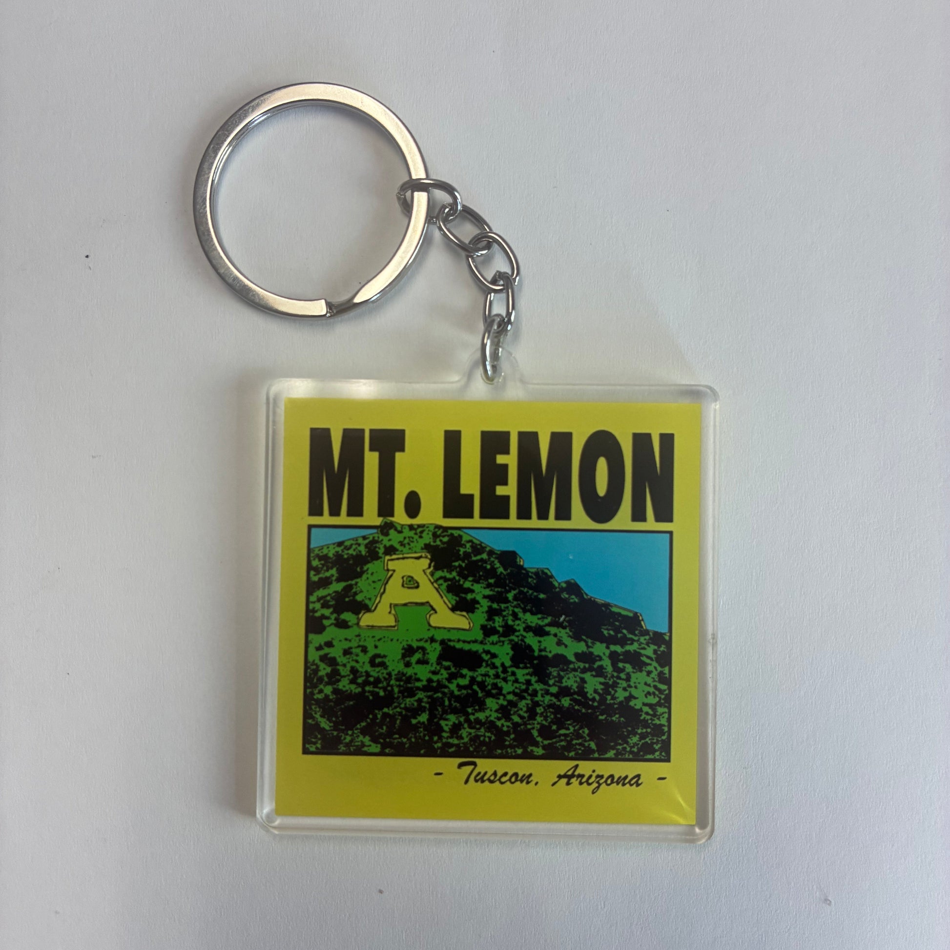 Keychain with a transparent tag featuring 'MT. LEMON' and a mountain graphic on yellow background. This image makes fun of the mistake folks make when referring to Mount Lemmon and A Mountain in Tucson, AZ.